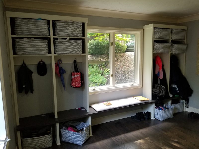 White mudroom lockers in use with coats, bags, and bins