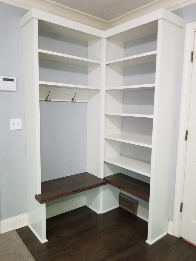 White corner lockers with open shelves and dark wood benches