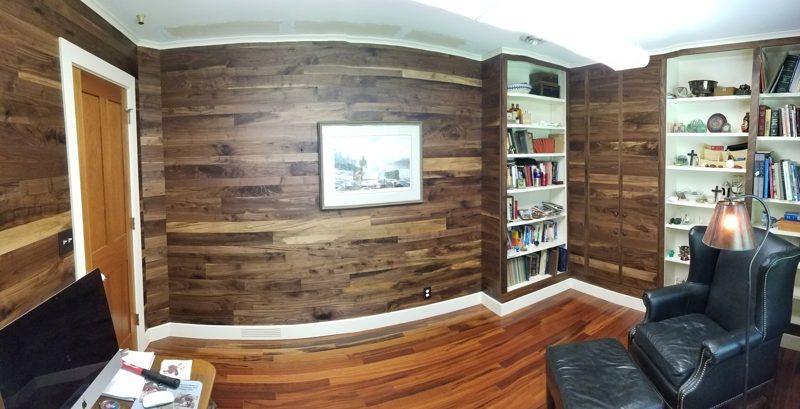 Office with wood plank walls, a built-in bookshelf, and a leather chair