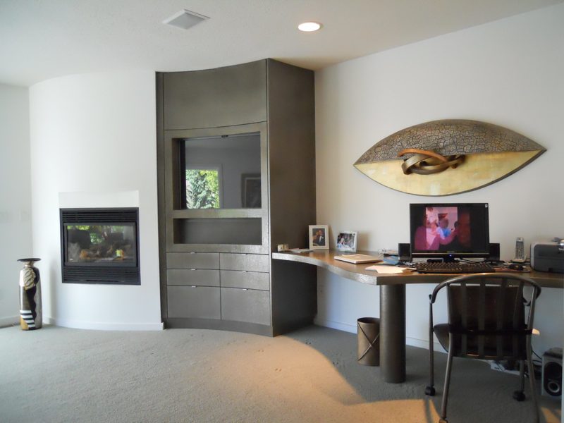 Gray office built-in with a fireplace, drawers, and a desk