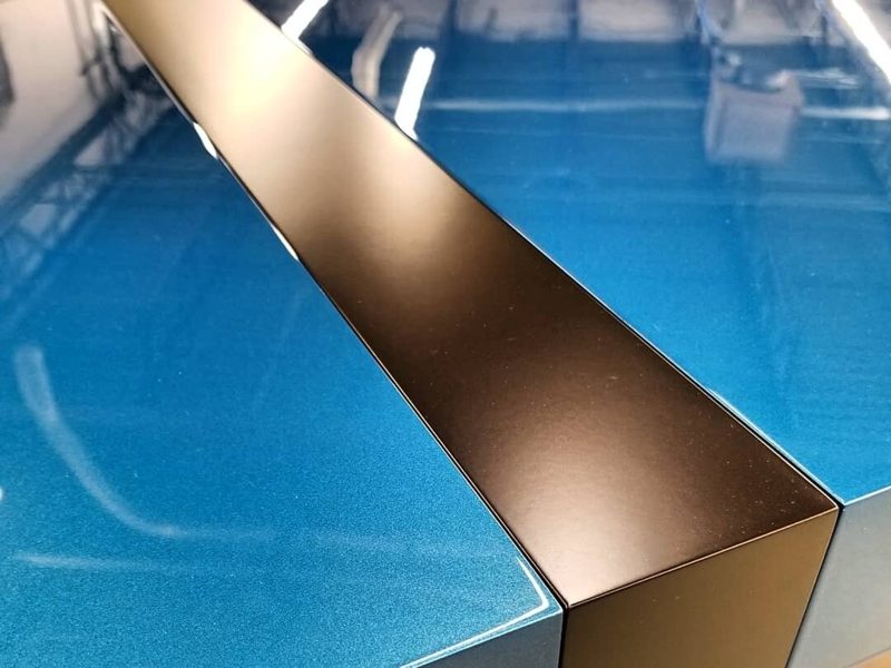 Close view of a glossy blue desktop and a dark inlaid stripe
