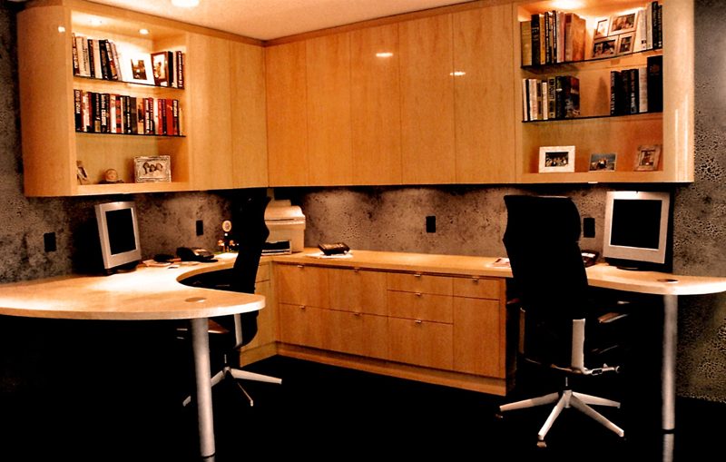 Light wood L-shaped office with upper cabinets, shelves, and two curved desks